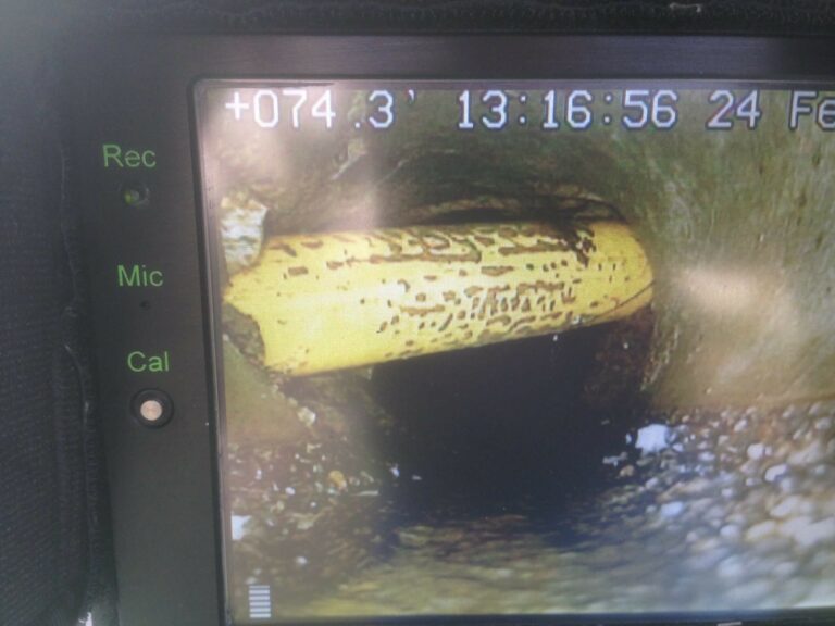 Photo of a gas line running through a sewer pipe!